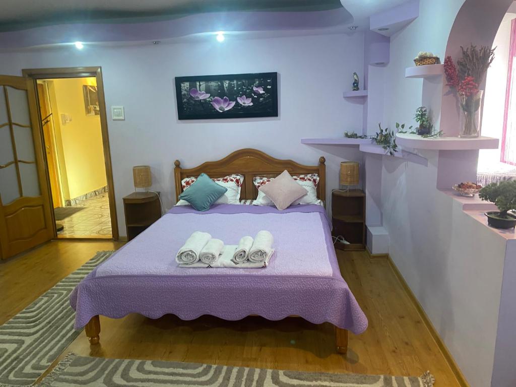 a bedroom with a bed with slippers on it at Central Home in Piatra Neamţ