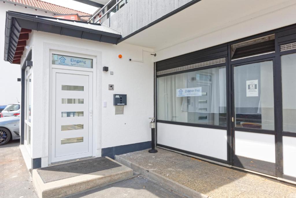 a white building with a white door and windows at Room4You - Bad Hersfeld in Bad Hersfeld