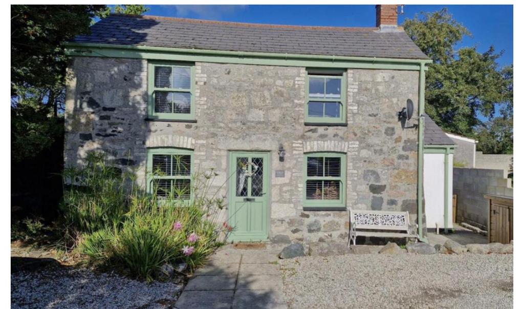 ein altes Steinhaus mit grüner Tür in der Unterkunft Buddleia Cottage Trewoon, St Austell in St Austell
