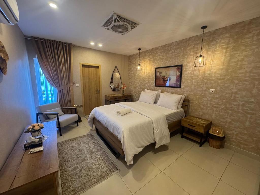 a bedroom with a large bed and a chair in it at Kazani Heights Luxurious apartments in Islamabad