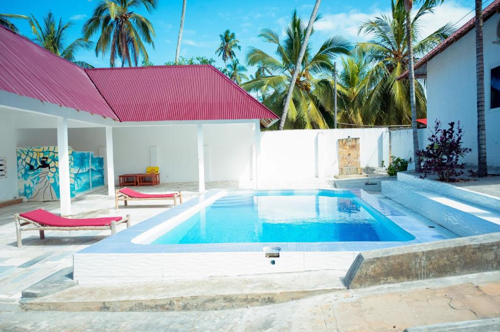 a swimming pool in front of a house at Vuai Bungalows & Restaurant in Kiwengwa