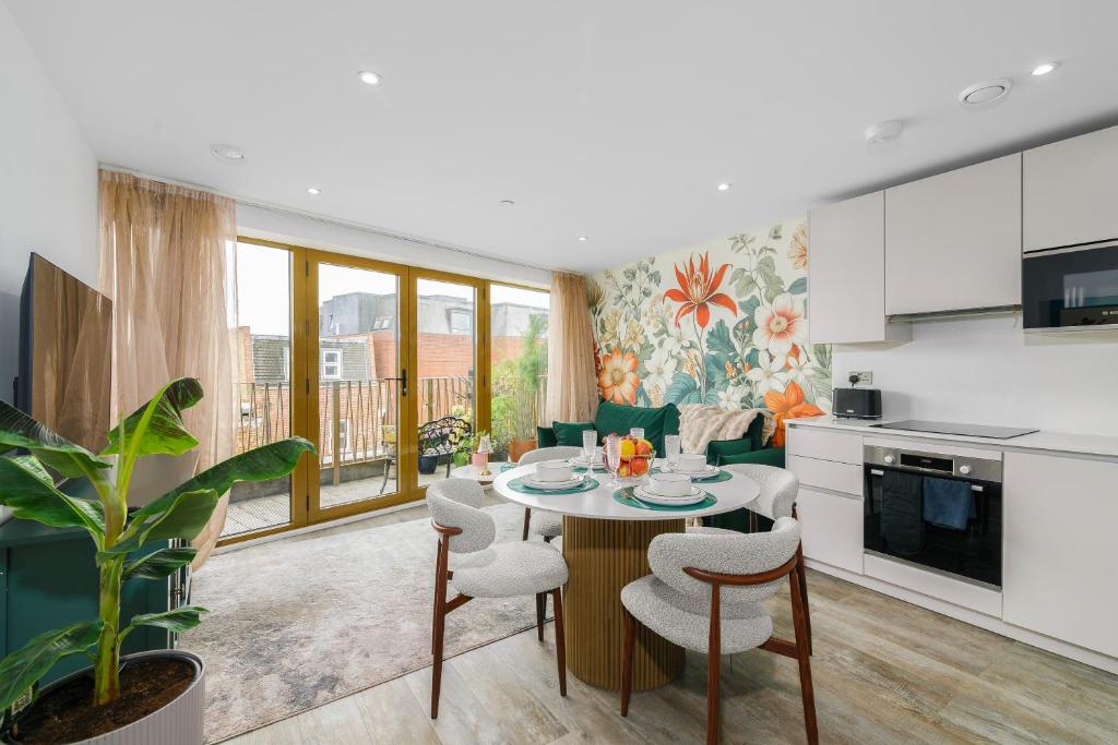 a kitchen and living room with a table and chairs at New in Willesden close to Oxford Str, Wembley, Jubilee line in London