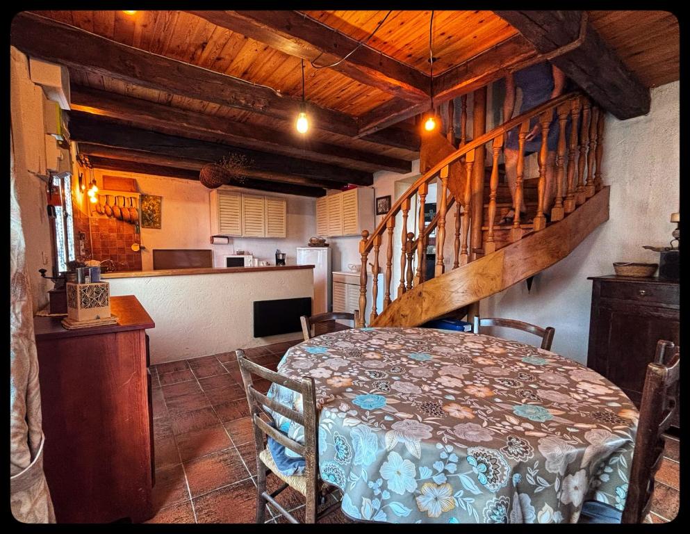 ein Esszimmer mit einem Tisch und einer Treppe in der Unterkunft Maison de montagne in Guillaumes