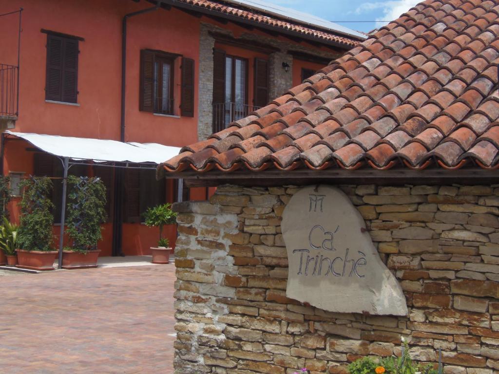 een gebouw met een bord aan de zijkant van een stenen muur bij Agriturismo Cà Trinche in Camo