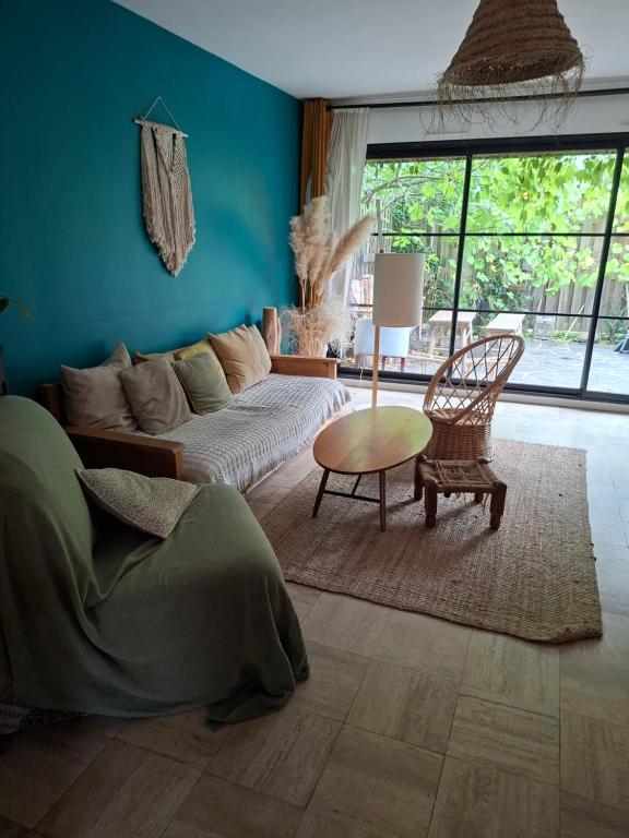 a living room with a couch and a table at MAISON FAMILIALE 4 CHAMBRE PISCINE 5mn DU CENTRE VILLE in Angers