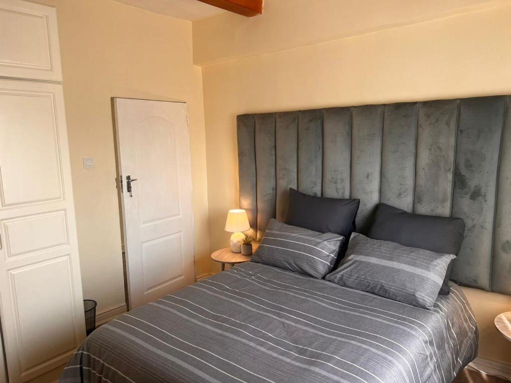 a bedroom with a large bed with a large headboard at Skimbo's Apartment in Lusaka