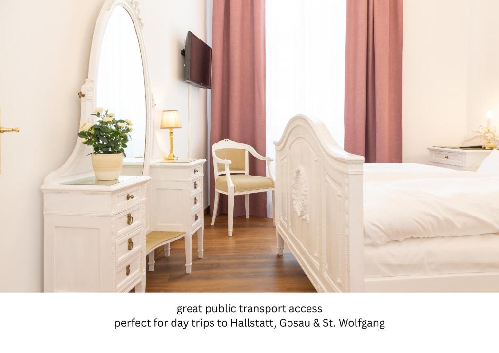 a white bedroom with a white dresser and a mirror at Heritage Boutique Apartments Bad Ischl in Bad Ischl