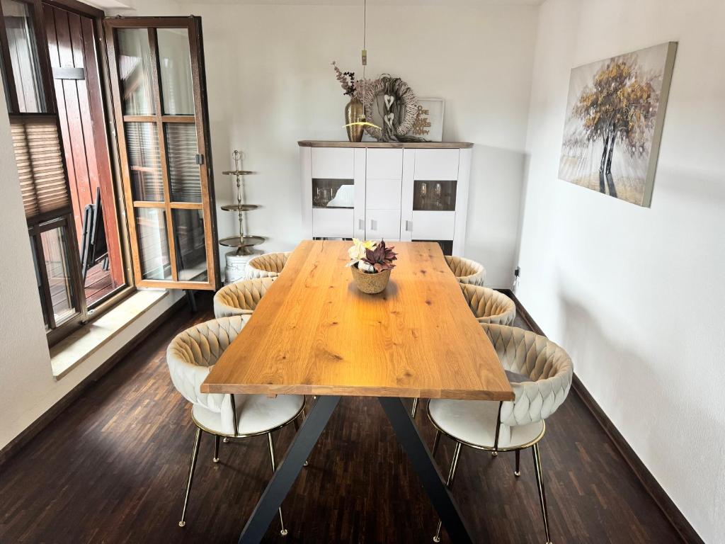 a wooden table with chairs in a room at Deluxe Maisonette Ferienwohnung in Köditz
