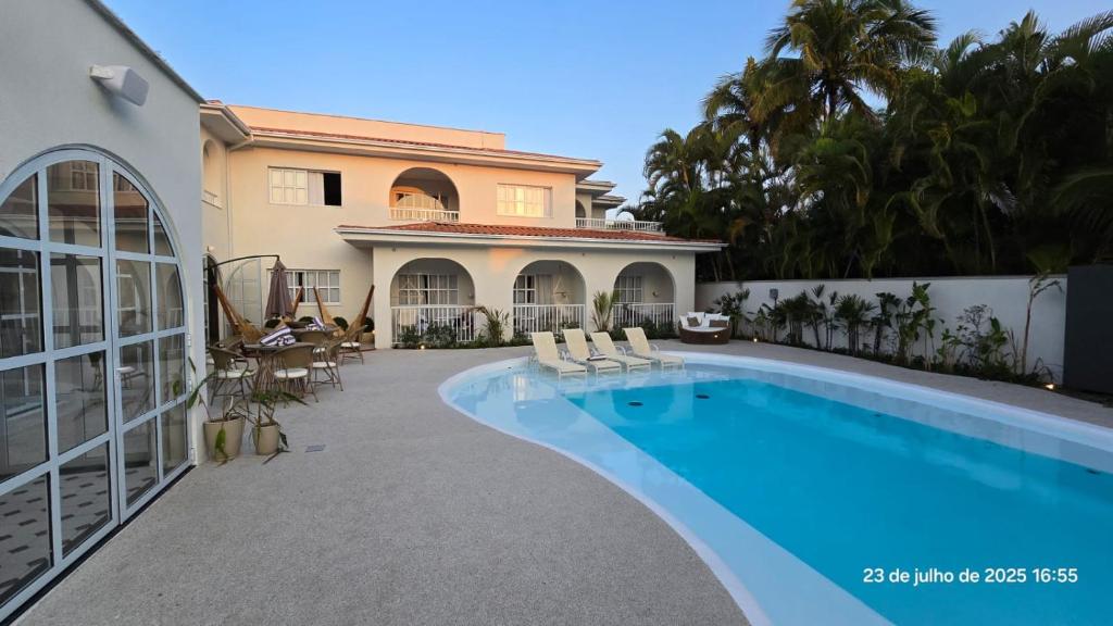 a swimming pool in front of a house at Santé Vivre L'expericénce, Búzios in Búzios