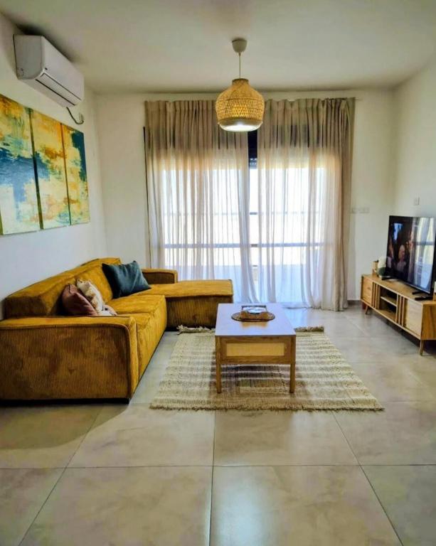 a person laying on a couch in a living room at נחת רוח Nachat Ruach in Mitzpe Ramon