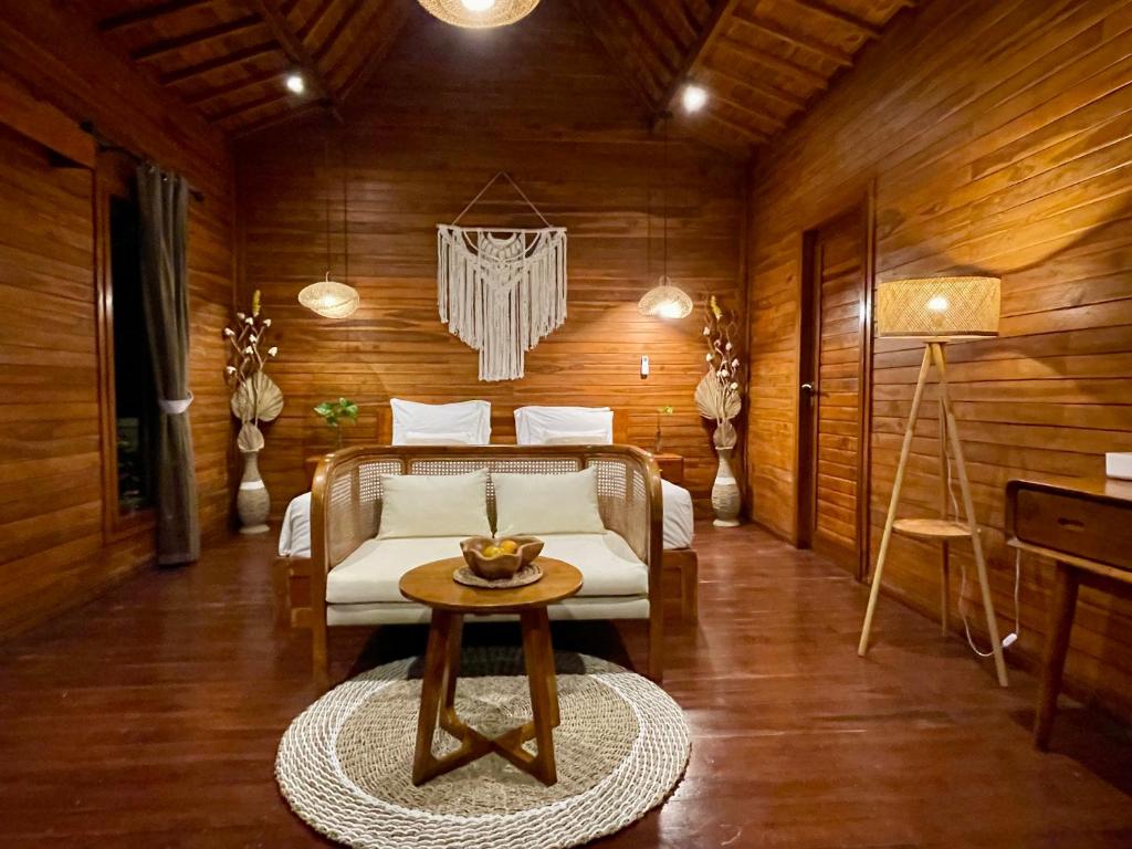 ウブドにあるEco Tini Villas Rice Fields and Jungle Viewの部屋にベッドとテーブルがある寝室