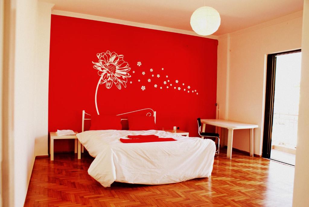 una camera da letto con una parete rossa e un fiore sopra di Acropolis View Dream ad Atene