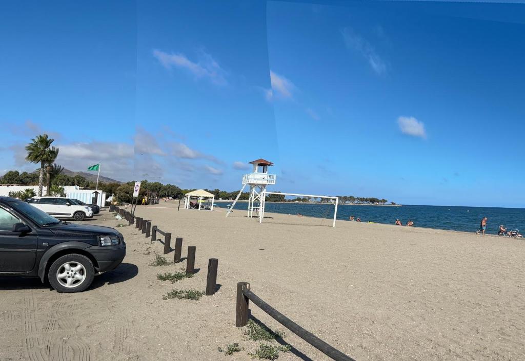 a car parked on a beach next to the ocean at Apartamento Torres in Las Bombardas
