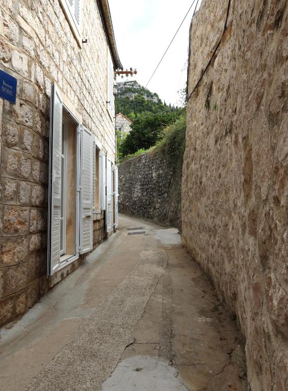 an alley between two stone buildings and a wall at Apartments Florian in Lopud