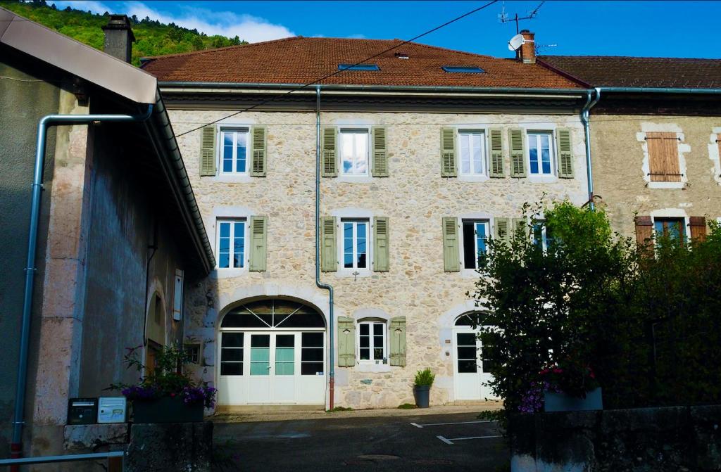 a large stone building with green doors and windows at La Colonie d'Antan in Collonges