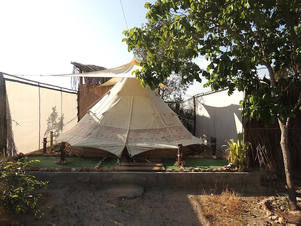 a large tent sitting in a yard next to a fence at Odara Glamping-Jalapão in Mateiros