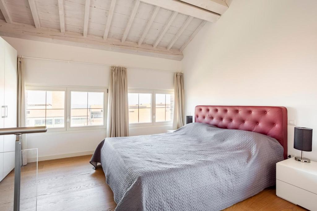 una camera con un grande letto e due finestre di WAVE'S GLASS Industrial loft in old Murano a Venezia