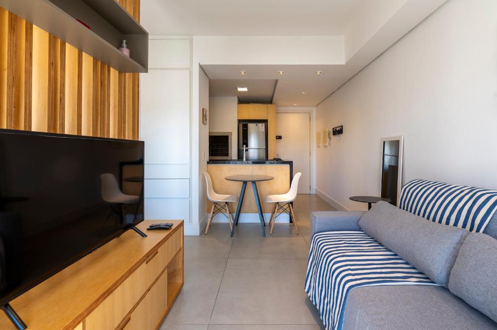 een woonkamer met een bank en een tv bij Apartamento top 40m2 Trend 24 Moinhos de Vento in Porto Alegre