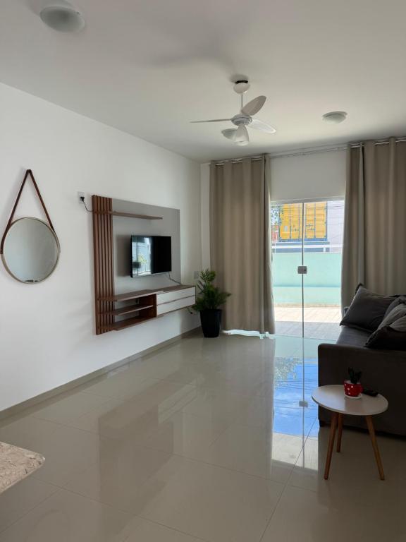 a living room with a couch and a tv at Residence Villa Vignoli in Arraial do Cabo