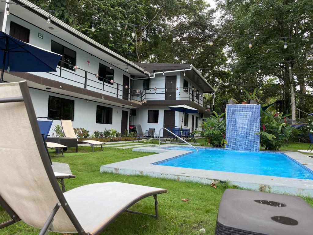 a house with a swimming pool and a chair at Hotel Azul Coral in Cahuita