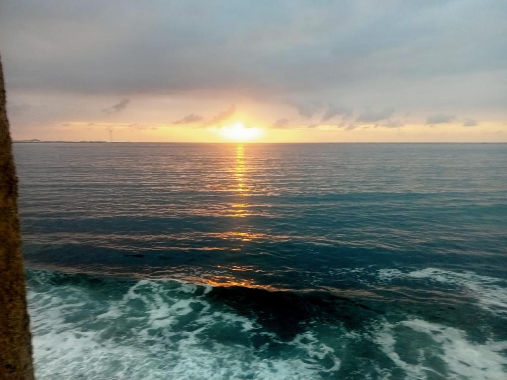 una vista del océano con el sol en el horizonte en Brisa C, en Agüimes