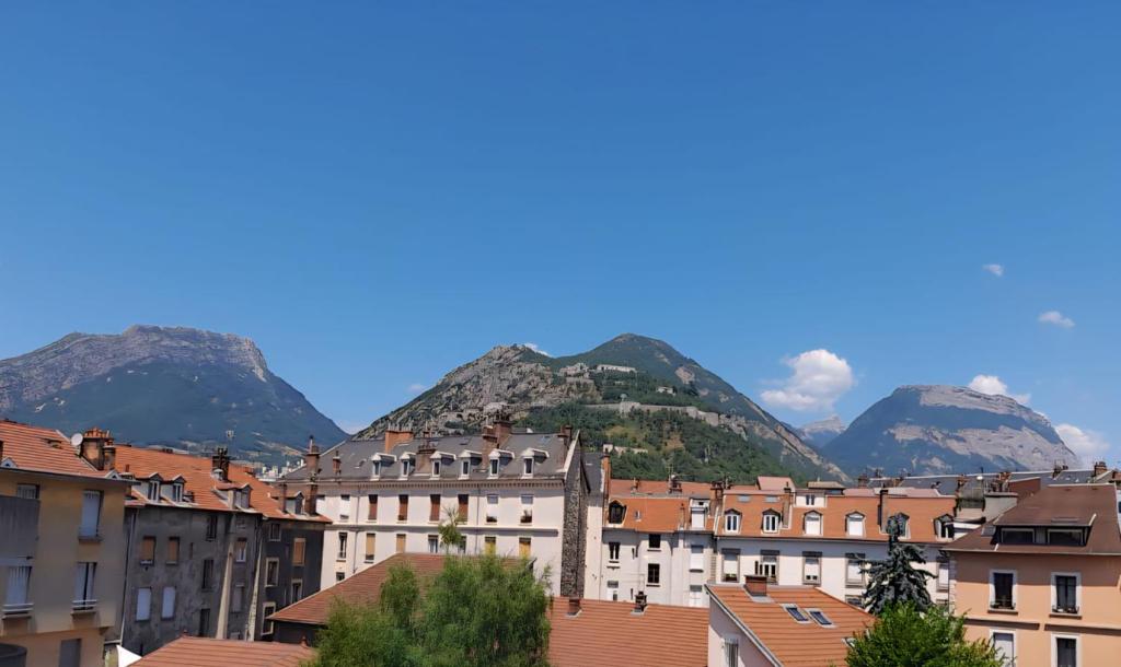 a view of a city with mountains in the background at Appartement élégant Championnet - 3 chambres - parking privé in Grenoble