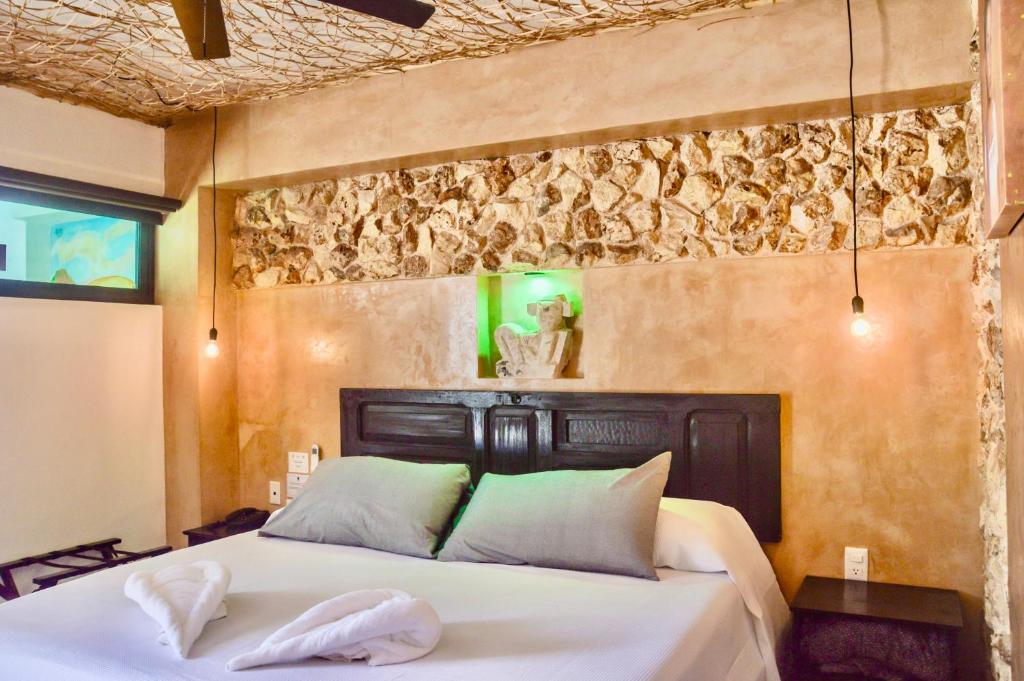 a bedroom with a bed with two towels on it at Habitaciones Colonial Zaci in Valladolid