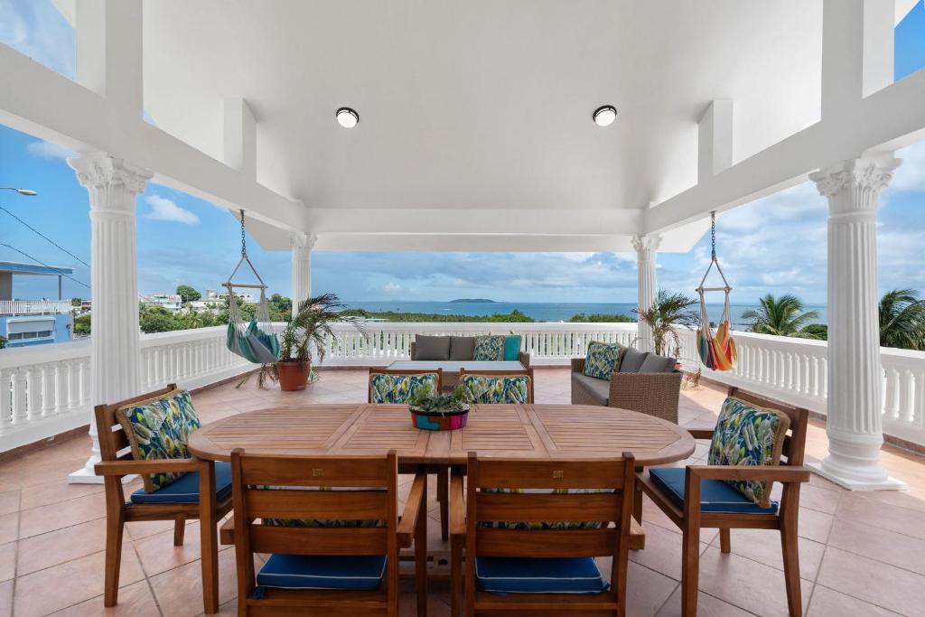 a dining room with a table and chairs on a balcony at Casa Blue Laguna I Tropical Scape with Ocean View in Las Croabas