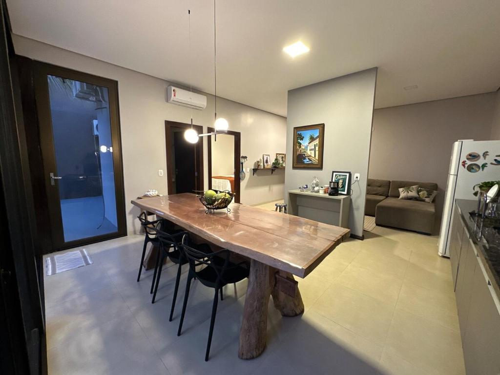 a living room with a wooden table and a couch at Recanto Tarumã in Tangara da Serra
