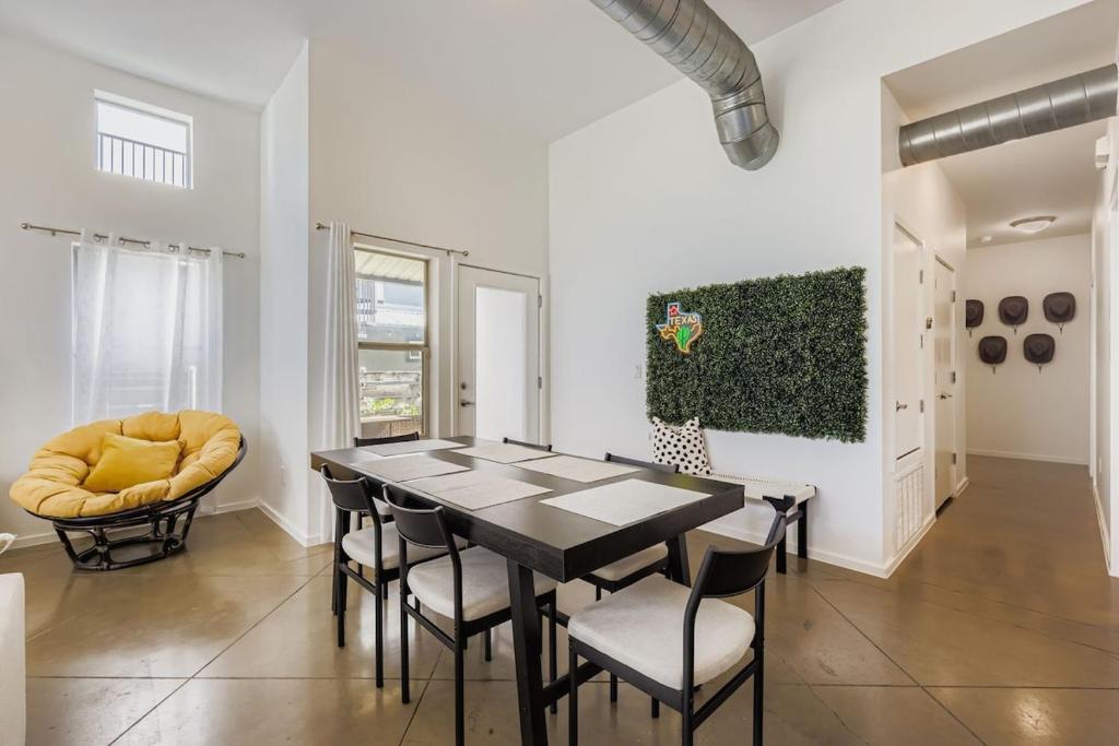 a dining room with a black table and chairs at SoCo Haven - Stylish Stay - Sleeps 8 & Wifi in Austin