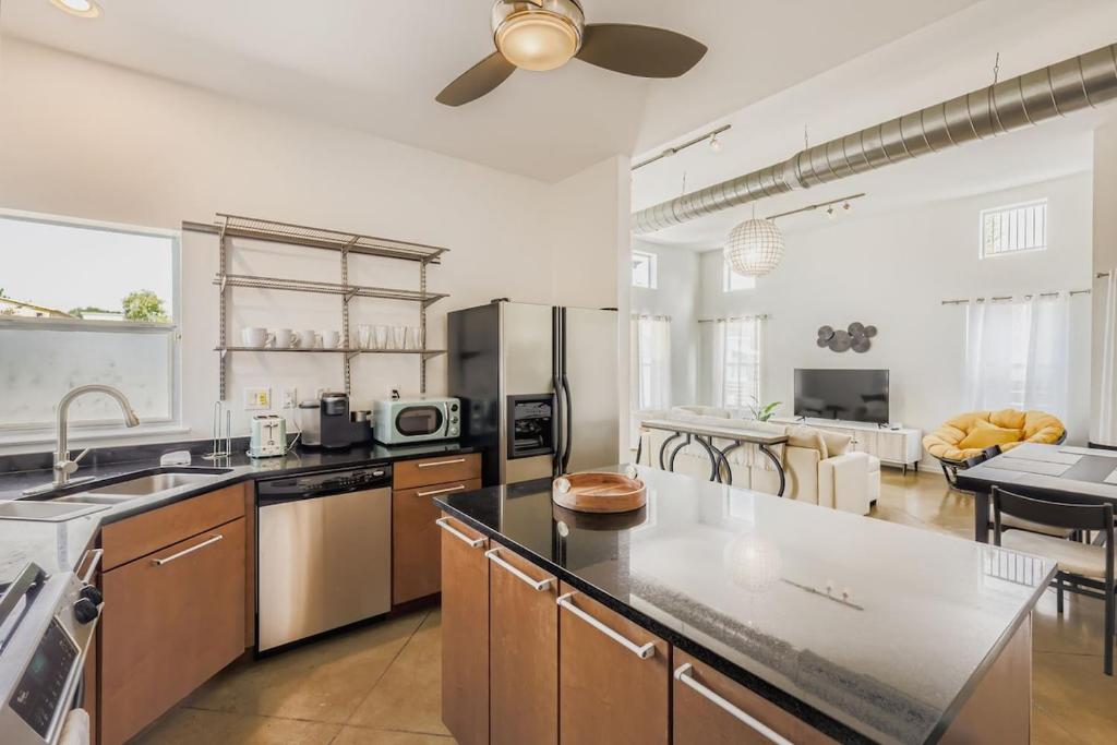 a kitchen with stainless steel appliances and a living room at SoCo Haven Retreat - Sleeps 8 - Wifi & Fire Pit in Austin