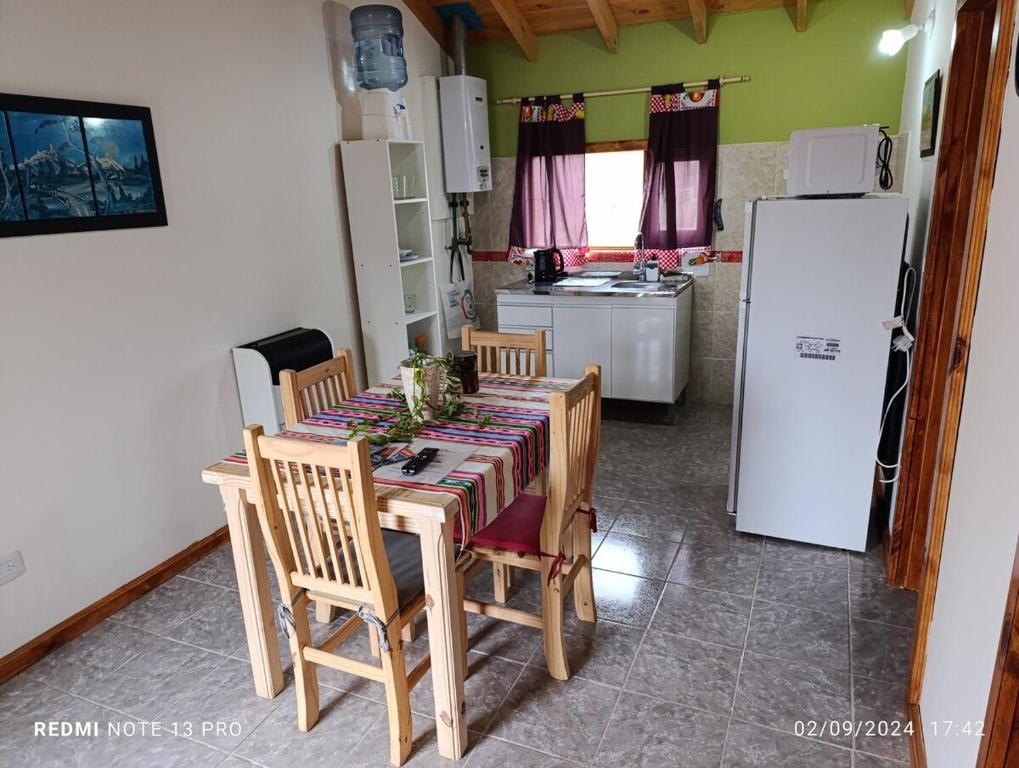 a kitchen with a table with chairs and a refrigerator at Cabana del aeropuerto calafate in El Calafate