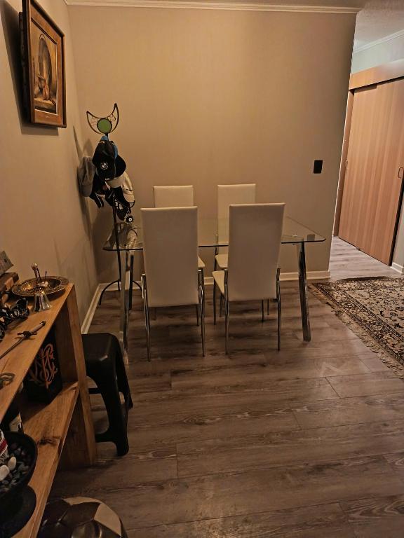 une salle à manger avec une table et des chaises blanches dans l'établissement Arriendo departamento amoblado por día, à Villa Alemana
