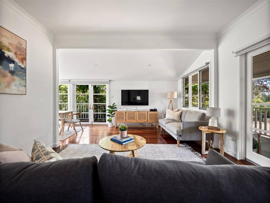 ein Wohnzimmer mit Sofa und Tisch in der Unterkunft Newberry Cottage - Beach, Games & Alfresco Bliss in Dunsborough