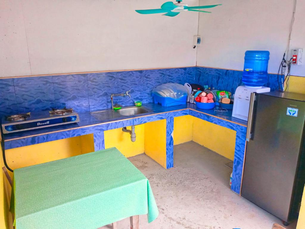 eine Küche mit einer blauen und gelben Arbeitsplatte in der Unterkunft Stockton Inn Siquijor in San Juan