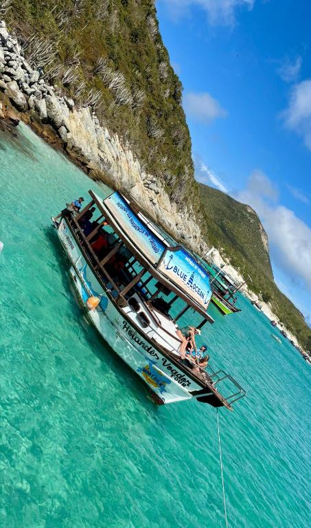 a group of boats in the water next to a mountain at Arraial do Cabo tour completo in Arraial do Cabo