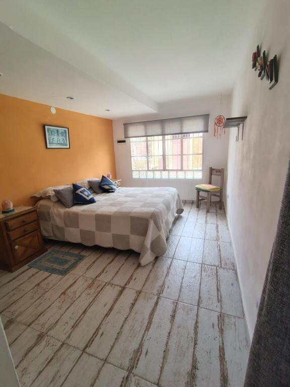 a bedroom with a large bed and a wooden floor at Tu Lugar en Capilla Del Monte in Capilla del Monte