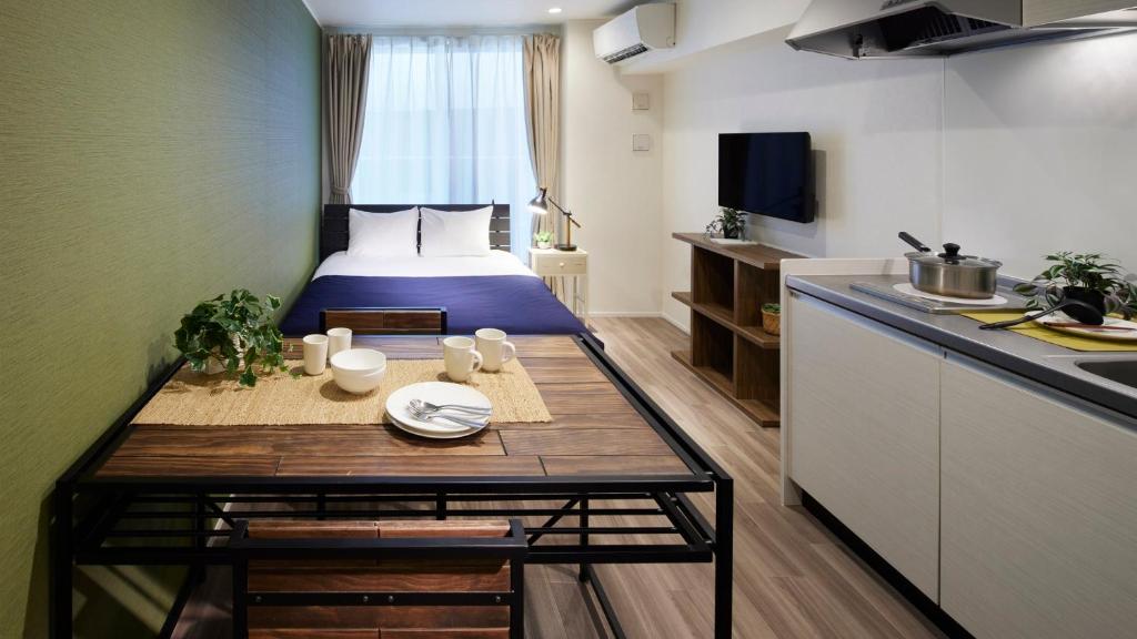a small apartment with a bed and a table in a kitchen at Minn Kamata in Tokyo