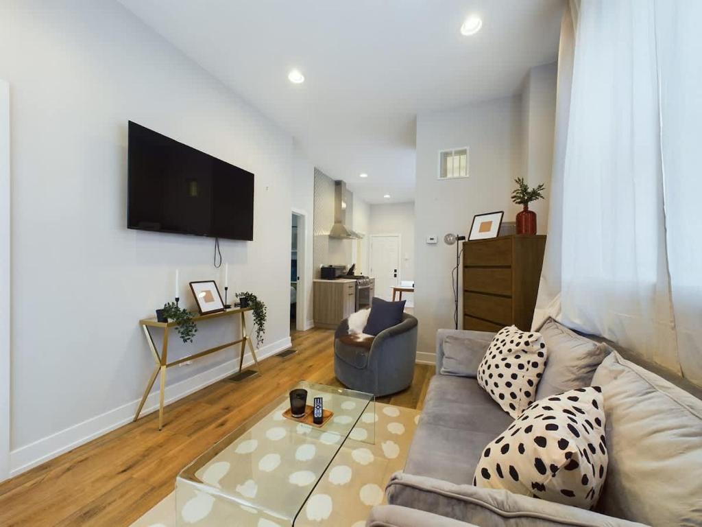 a living room with a couch and a flat screen tv at West Town 2BR with In-Unit Laundry and Onsite Parking in Chicago