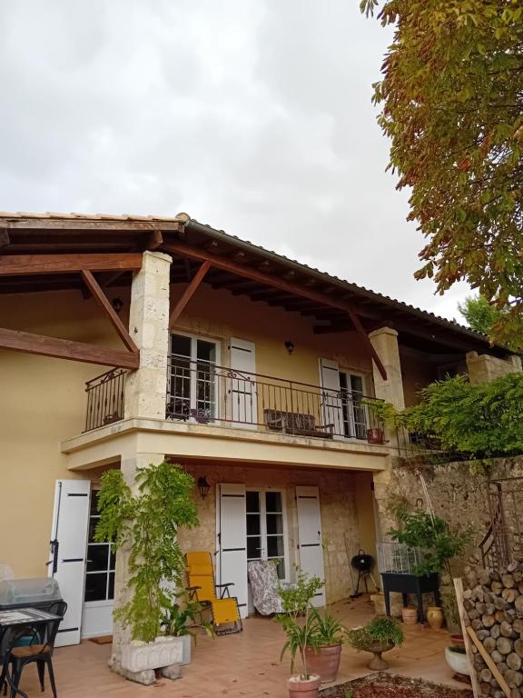 a house with a balcony and a patio at Gite de la Mouline in Lectoure