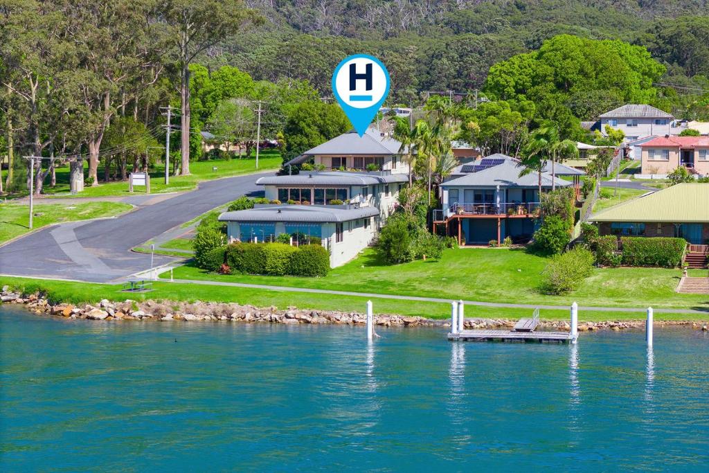 an aerial view of a house next to a body of water at Slipways in Laurieton