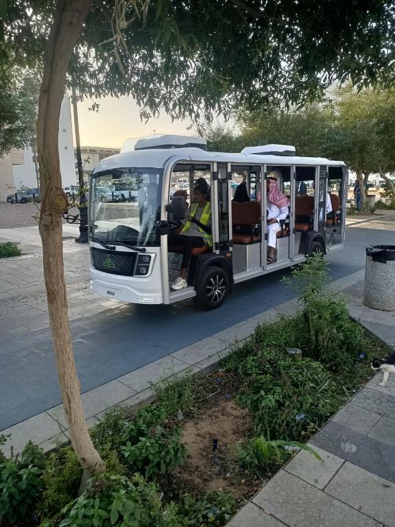 メディナにあるغرف اهل المدينه مفروشه مكيفهの人々が乗っている小さな白いバス