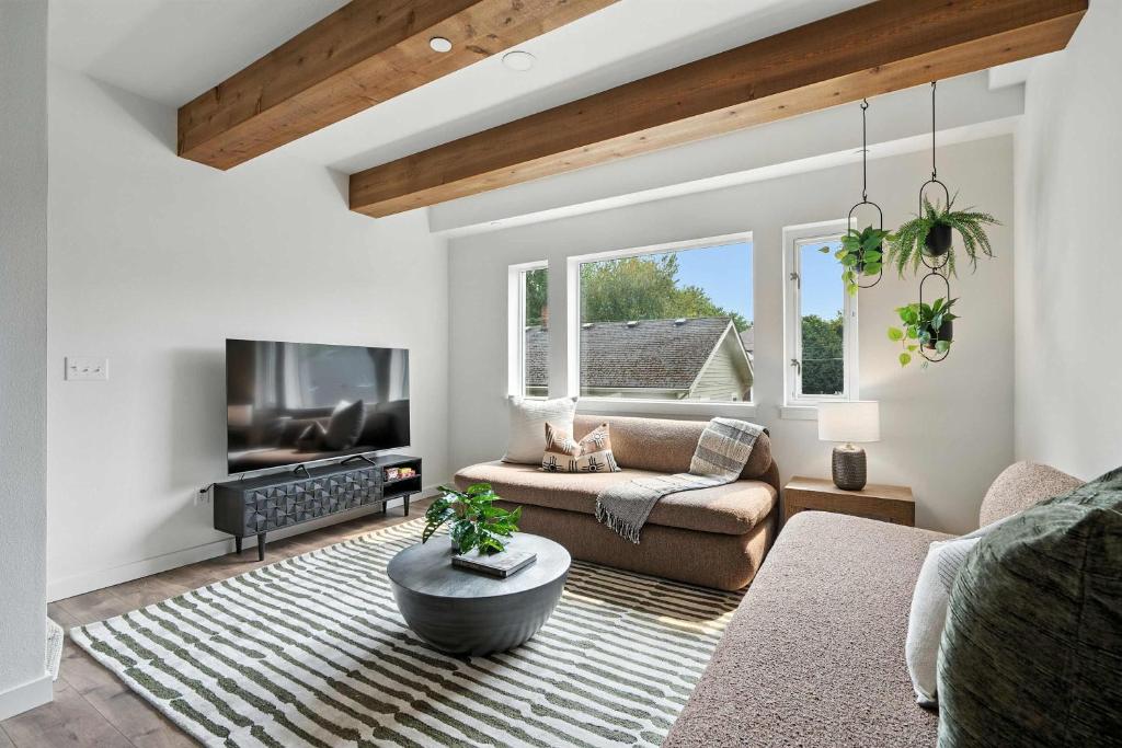 a living room with a couch and a tv at The Adelynn 5BR - Sleek - Spacious - Walkable in Portland