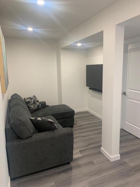 a living room with a couch and a flat screen tv at Friendly Extended Stay and Comfort in Winnipeg