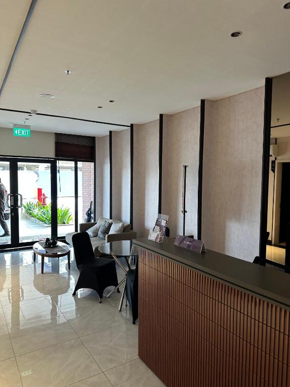 a hotel lobby with a reception desk and a couch at ARTsC Newville Luxury in Leuweungmalang