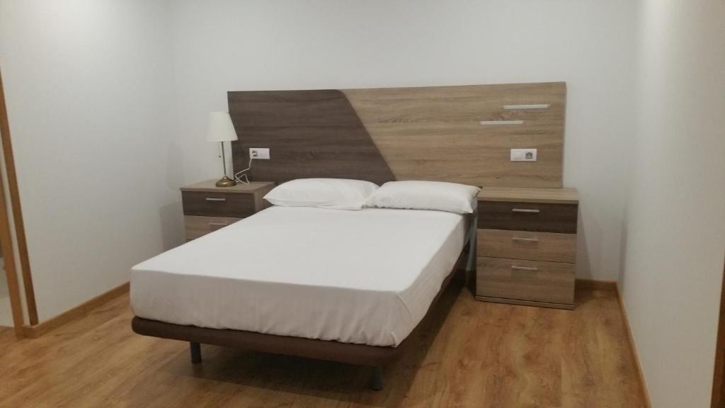 a bedroom with a bed and a wooden headboard at Fermont in Foz