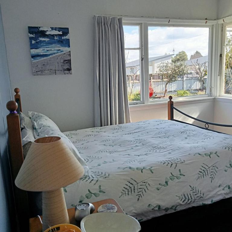 a bedroom with a bed and a large window at Dated but Delightful on D'Arcy in Richmond