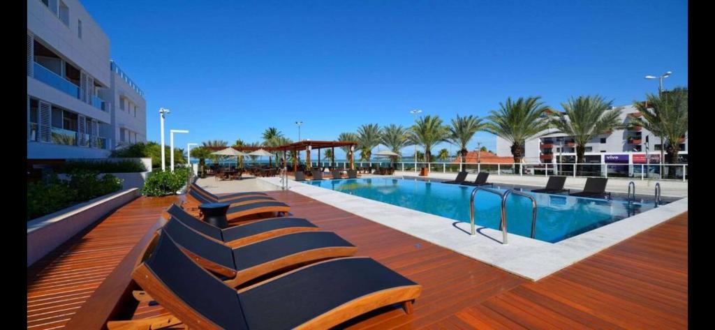 a row of benches sitting next to a swimming pool at Loft Alto padrão na beira mar de Tambaú in João Pessoa