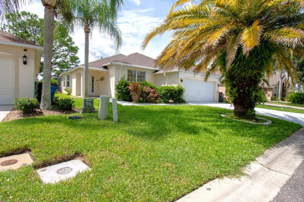 une maison avec un palmier dans la cour dans l'établissement Oasis at the famous Southern Dunes golf course, à Haines City