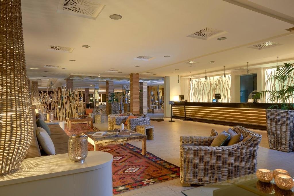 a lobby with couches and chairs and a table at Meliá Cala Galdana in Cala Galdana